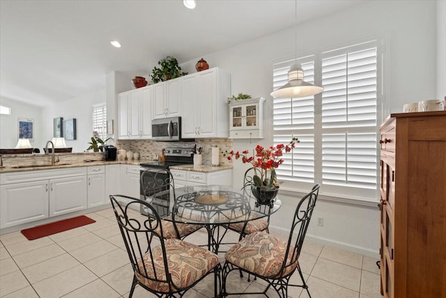 kitchen with white cabinets, sink, stainless steel appliances, and hanging light fixtures