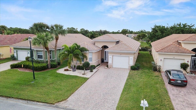 mediterranean / spanish-style home featuring a garage and a front lawn