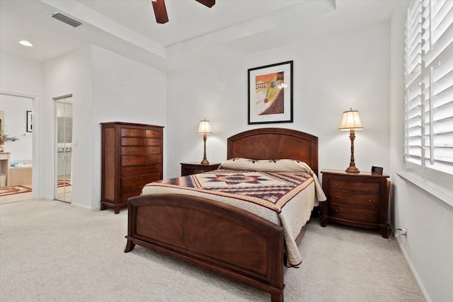 bedroom featuring connected bathroom, ceiling fan, and light colored carpet