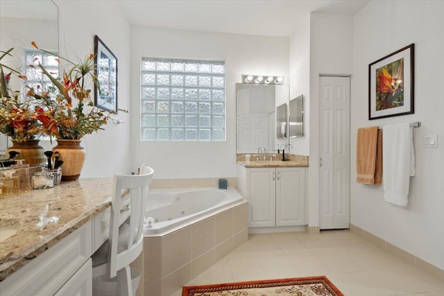 bathroom with tile patterned floors, vanity, and tiled tub