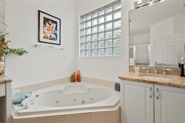 bathroom featuring vanity and a relaxing tiled tub