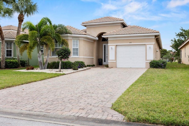 mediterranean / spanish house with a front lawn and a garage