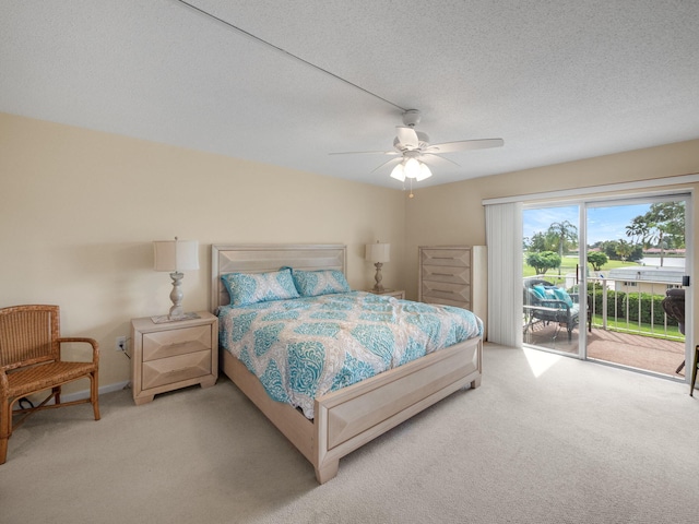 carpeted bedroom with access to outside, ceiling fan, and a textured ceiling