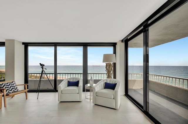 sunroom / solarium with a water view and a view of the beach