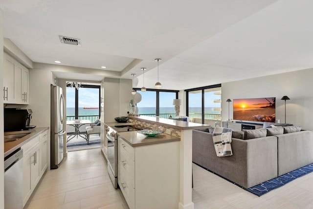 kitchen featuring white cabinets, pendant lighting, sink, and appliances with stainless steel finishes