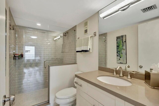 bathroom with vanity, an enclosed shower, and toilet