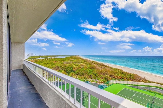 balcony with a water view and a view of the beach