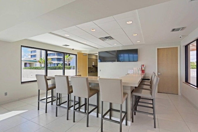 kitchen featuring a kitchen bar, kitchen peninsula, and light tile patterned floors