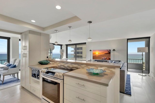 kitchen with hanging light fixtures, a water view, a healthy amount of sunlight, and stainless steel electric range