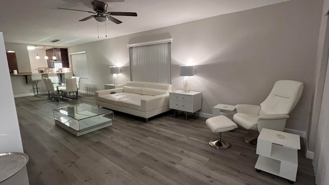 living room featuring ceiling fan and dark wood-type flooring