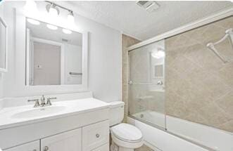 full bathroom with vanity, toilet, and bath / shower combo with glass door