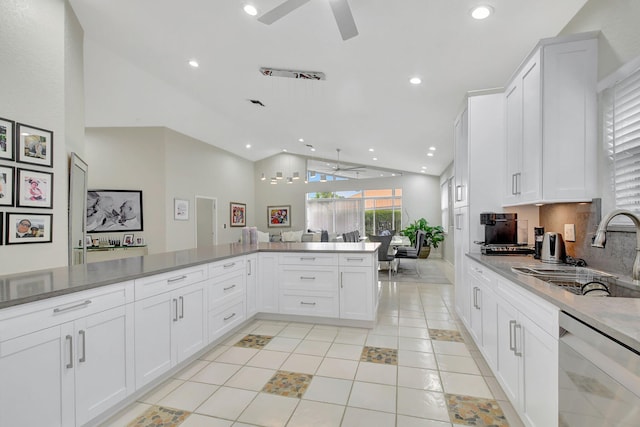 kitchen with dishwasher, sink, light tile patterned floors, kitchen peninsula, and white cabinets