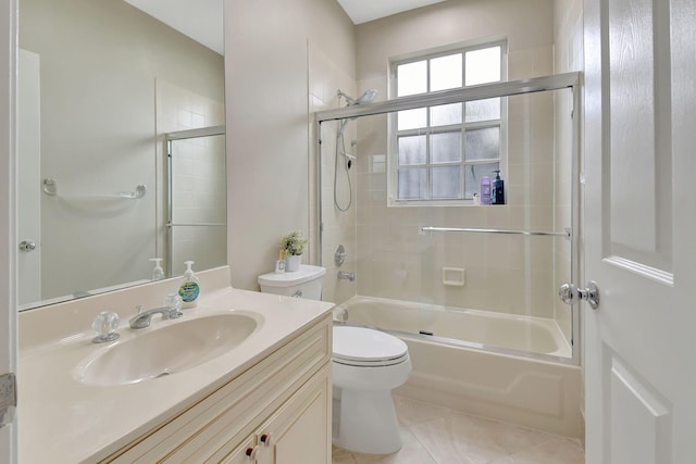 full bathroom with tile patterned flooring, vanity, bath / shower combo with glass door, and toilet