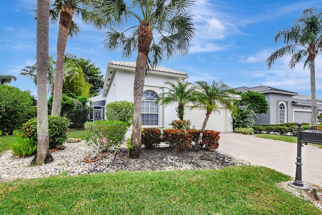 mediterranean / spanish-style home with a front yard and a garage