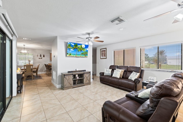 tiled living room with a textured ceiling and ceiling fan