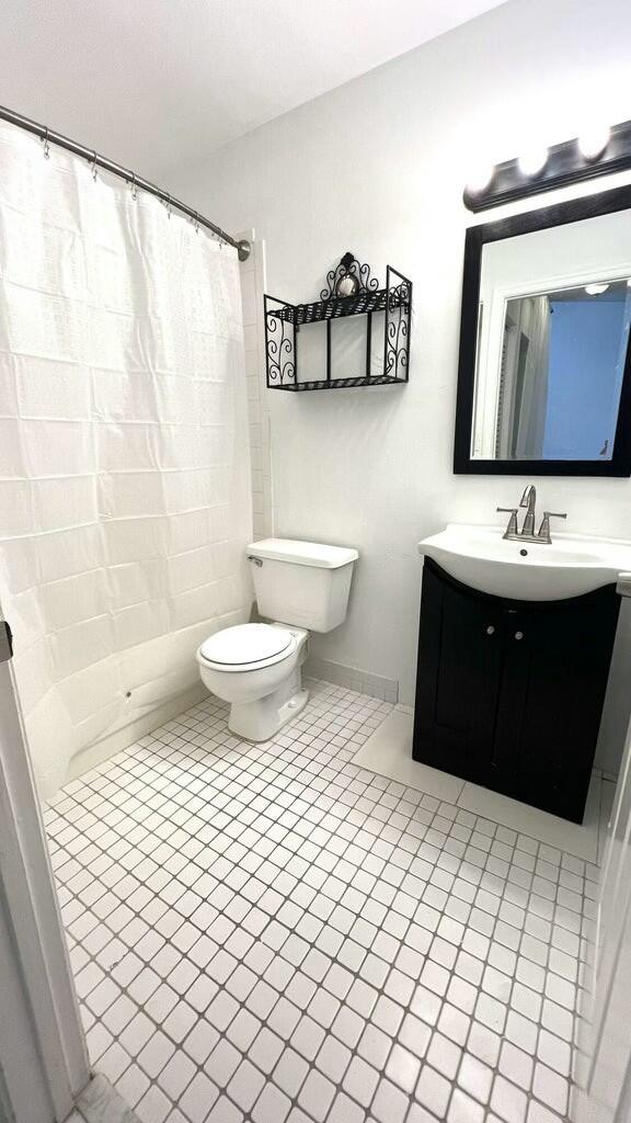 bathroom with tile patterned flooring, vanity, and toilet