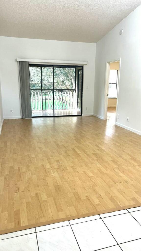 unfurnished room featuring light hardwood / wood-style flooring and a textured ceiling