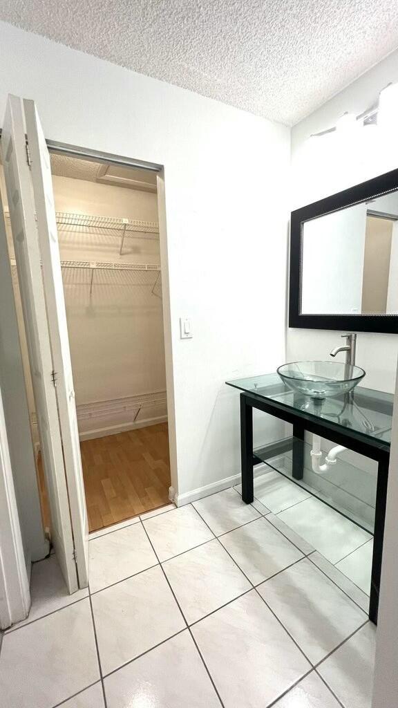 bathroom featuring tile patterned floors, sink, and a textured ceiling