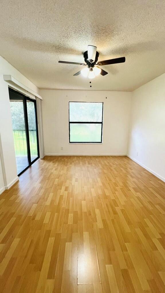 spare room featuring a textured ceiling, light hardwood / wood-style floors, and ceiling fan