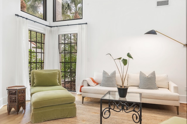 sitting room with hardwood / wood-style floors and a high ceiling