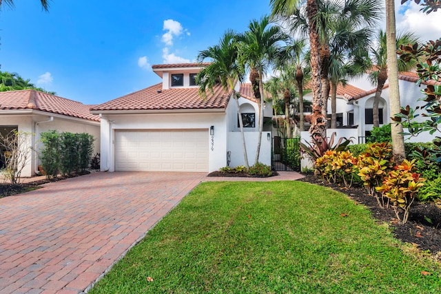 mediterranean / spanish-style home featuring a garage and a front lawn