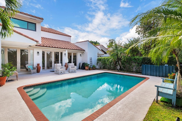 view of swimming pool with french doors and a patio