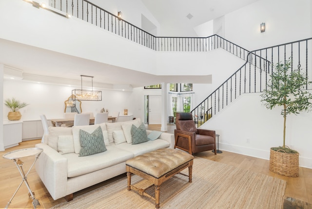 living room with light wood-type flooring and a high ceiling