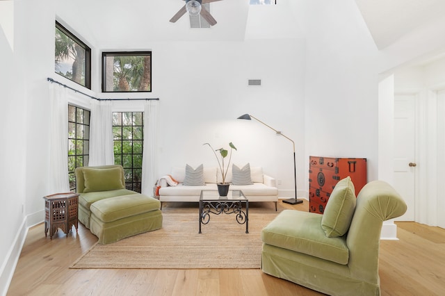 sitting room featuring hardwood / wood-style flooring, ceiling fan, and high vaulted ceiling