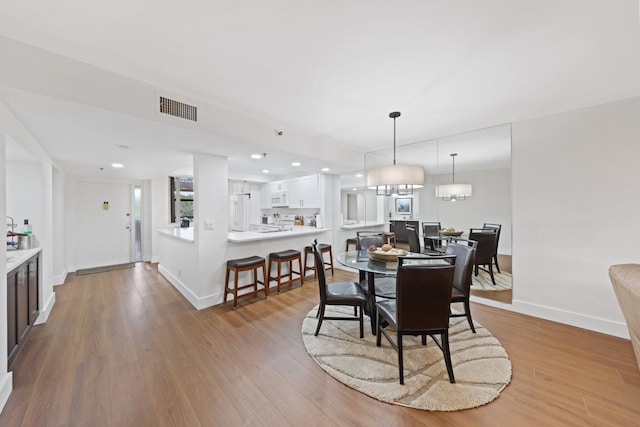 dining space with wood-type flooring