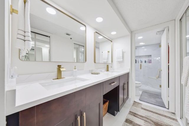 bathroom with vanity, toilet, and a shower with door