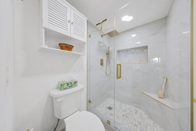 bathroom featuring toilet and a shower with shower door