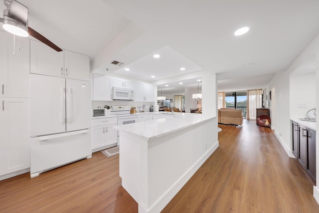 kitchen featuring kitchen peninsula, light stone countertops, light wood-type flooring, white appliances, and white cabinetry