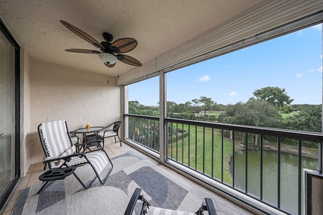 balcony featuring ceiling fan and a water view