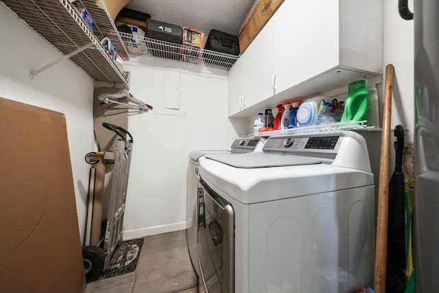 laundry area featuring light hardwood / wood-style flooring, cabinets, a textured ceiling, and independent washer and dryer