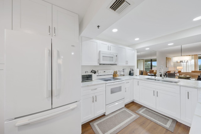 kitchen with white appliances, dark hardwood / wood-style floors, white cabinetry, and sink