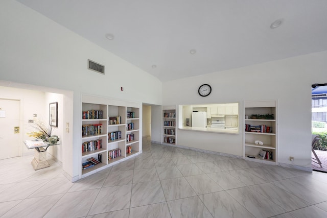 unfurnished living room featuring built in features and high vaulted ceiling