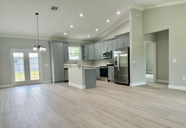 kitchen featuring gray cabinetry, a center island, ornamental molding, appliances with stainless steel finishes, and decorative light fixtures