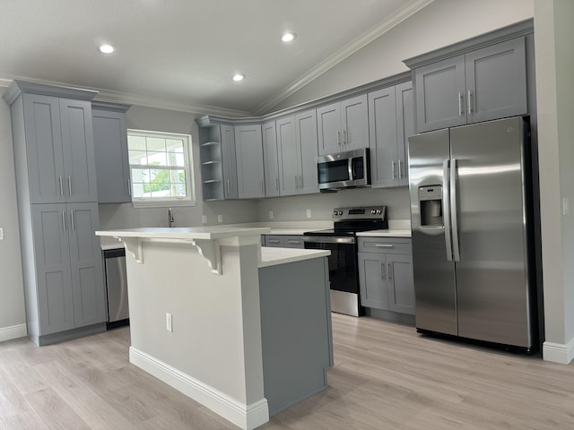 kitchen with gray cabinetry, appliances with stainless steel finishes, and vaulted ceiling