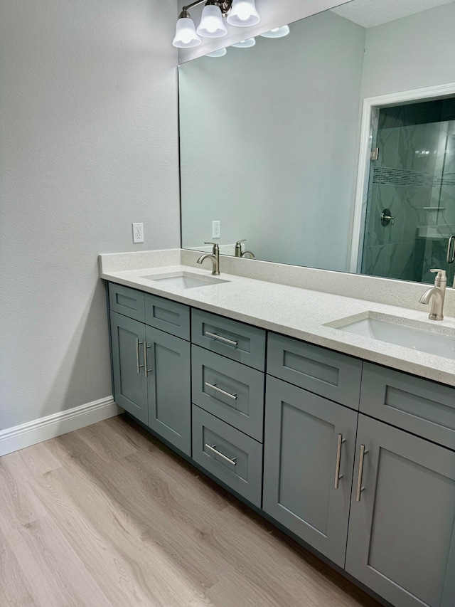 bathroom with hardwood / wood-style floors, vanity, and a shower with door