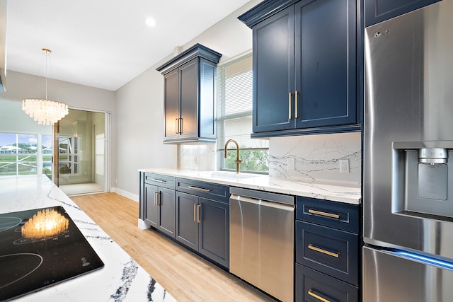 kitchen featuring decorative light fixtures, stainless steel appliances, an inviting chandelier, and plenty of natural light