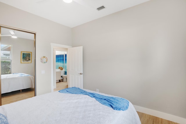 bedroom with ceiling fan, light hardwood / wood-style floors, and a closet