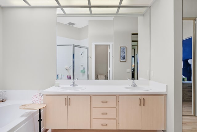 full bathroom with hardwood / wood-style floors, vanity, independent shower and bath, and toilet