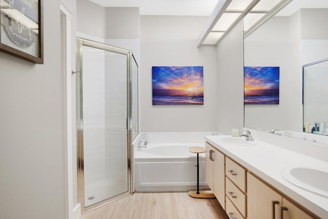 bathroom with hardwood / wood-style flooring, vanity, and independent shower and bath