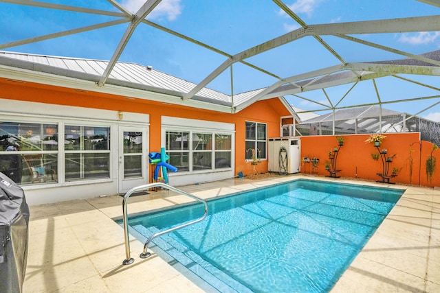 view of pool featuring glass enclosure and a patio