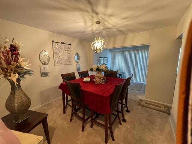 carpeted dining space featuring a chandelier