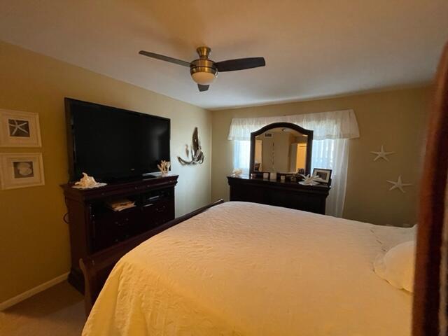 bedroom with carpet floors, a ceiling fan, and baseboards