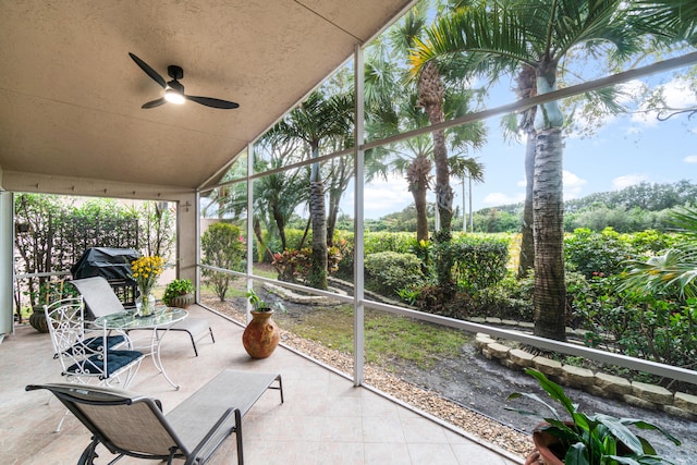 sunroom with ceiling fan, a healthy amount of sunlight, and vaulted ceiling