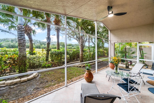 unfurnished sunroom featuring ceiling fan