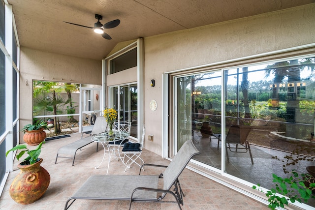 sunroom / solarium with ceiling fan and vaulted ceiling