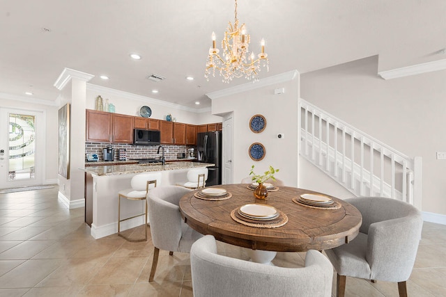 tiled dining room featuring a notable chandelier, crown molding, and sink